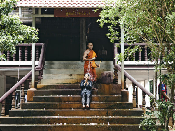 Angkor w jeden dzień. Mnich polewa głowę kobiety wodą. Błogosławieństwo. Kambodża.