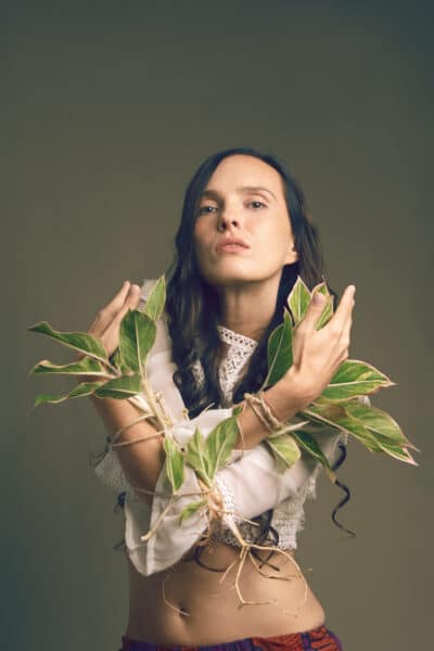 kobieta stojąca w studio ręce związane roślinną kompozycją