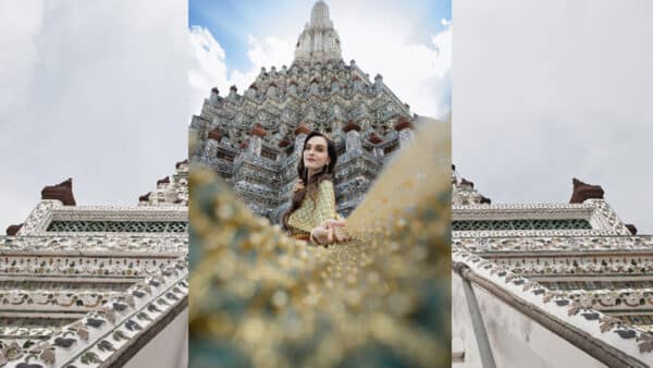Kobieta w tradycyjnym tajskim stroju na tle Wat Arun w Bangkoku.
