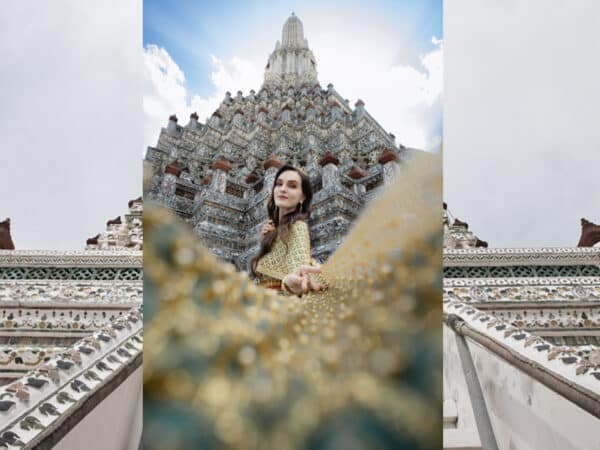 Kobieta w tradycyjnym tajskim stroju na tle Wat Arun w Bangkoku.